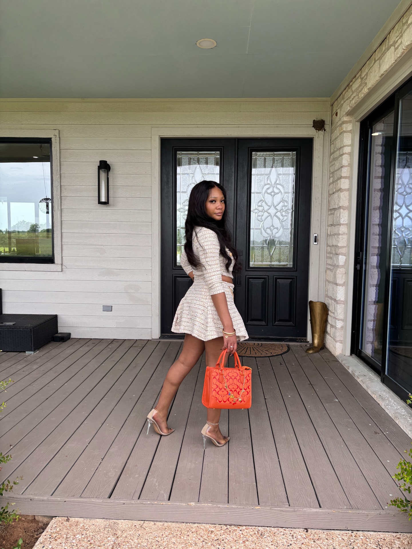 La'Ray, founder of the Lirael Luxe curated purse boutique, holding a structured burnt-orange leather handbag with antique gold hardware